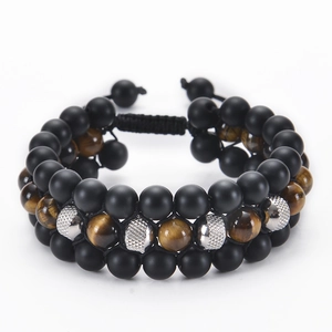 Detailed view of triple-layered braided bracelet with black lava stone and tiger eye beads