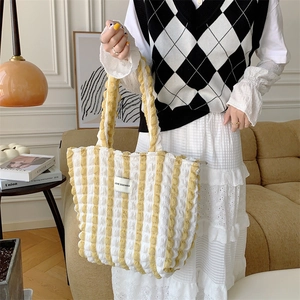 Detail of yellow striped bubble puff tote bag with Love Sozakka label in a cozy setting