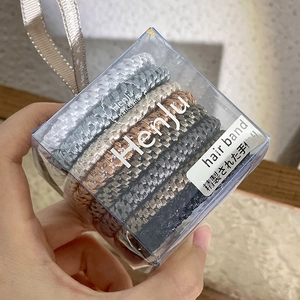 Close-up of spiral hair ties set in a transparent square box with a branded ribbon