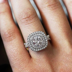 Macro shot of double halo engagement ring with pavé diamonds on a silver band