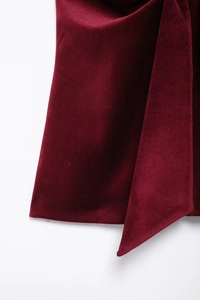 Vue macro du tissu en velours rouge foncé montrant une texture et un fini brillant