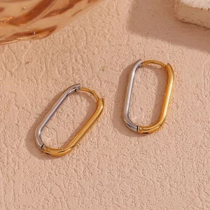 Detail of oval two-tone earrings in silver and 18K gold plated stainless steel