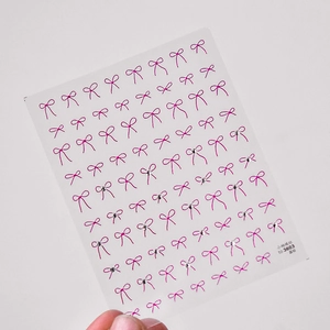 Detailaufnahme von rosa Schleifen Nageltattoo mit Strasssteinen und Modellnummer to 3603