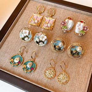Vintage floral pearl oil painting earrings collection displayed on beige linen tray
