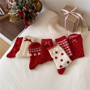 Detail of red and white cotton mid-calf socks set with festive holiday patterns