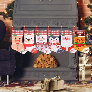 Set of 6 festive Christmas stockings featuring Santa and reindeer hung on fireplace mantle