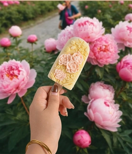 Vista exterior de un molde para helado con relieve 3D de peonía en crema y rosa