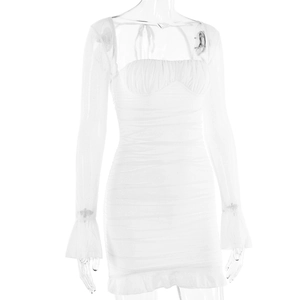 Detail of the white mesh dress featuring layered ruffles and textured ruched fabric
