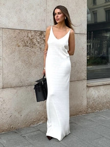 Detailed texture of white knitted maxi dress with V-neckline and elegant thin straps