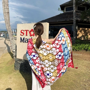 Outdoor shot of an ethnic geometric pattern large sun-protective shawl at a sunny beach resort