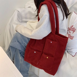 Detail of burgundy plush tote bag with four front pockets and colorful button accents
