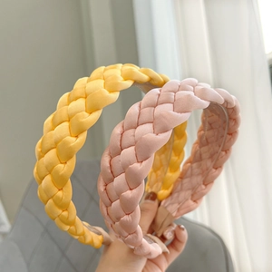 Close-up of pink and yellow braided fabric headbands with elegant silk texture