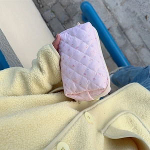 Handheld pink quilted makeup bag with cute rabbit print and floral pattern detailing