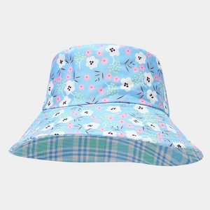 Detail of the reversible bucket hat showing blue floral pattern and plaid lining texture