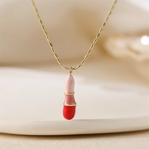 Macro d'un collier pendentif capsule doré avec détails en émail rose et rouge vif