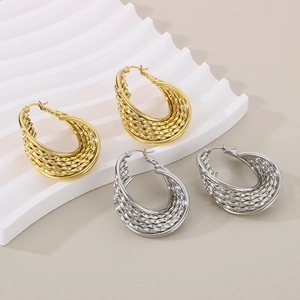 Détail de boucles d'oreilles torsadées en U en or et argent sur présentoir