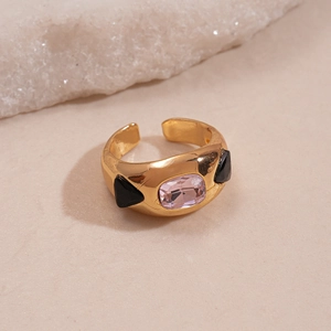 Close-up of vintage gold adjustable ring featuring pink rectangular gemstone and black triangles