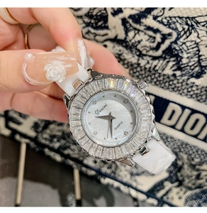 Macro detail of luxury women watch with rhinestone bezel and ceramic band on wrist