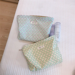 Detailed view of floral cotton makeup bags with zippers and Simple Wish label on white fabric