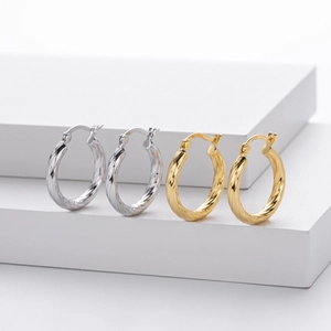 Detailed close-up of S925 hallmark on twisted hollow tube hoop earrings in gold and silver