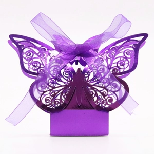 Detail of laser-cut butterfly candy box in purple with intricate wing patterns and ribbon