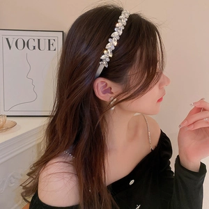 Close-up of sparkling silver headband with marquise and round crystals on female model