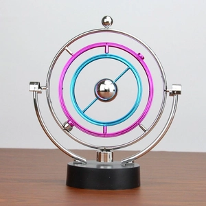 Close-up of concentric silver, pink and blue kinetic metal rings on a black base