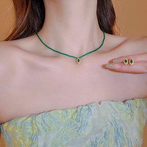 Vintage emerald-style jewelry set with zircon necklace and teardrop earrings on a model