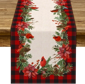 Detail of Christmas table runner with cardinal bird and poinsettia on rustic wood