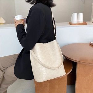 Fashionable beige bucket bag with crocodile embossed texture and wide shoulder strap