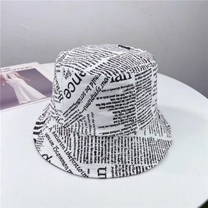 Détail d'un chapeau bob imprimé journal vintage sur table avec magazine de mode