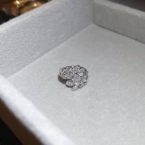 Close-up of white gold leaf ring with zircon stones in a grey velvet jewelry box
