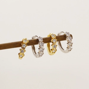 Detailed view of gold and silver S925 sterling silver earrings with star-shaped gems