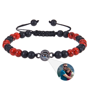 Detail of beaded projection bracelet with red and black stones showing custom photo feature