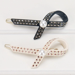 Detailansicht der diamantbesetzten Haarklammern in Schwarz und Beige mit Perlen