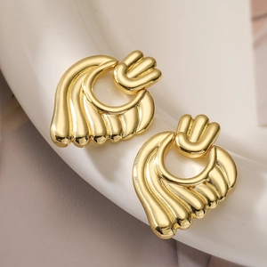 Fashionable golden heart-shaped shell earrings with metallic luster on white ceramic