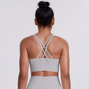 Detail of light grey sports bra featuring multiple cross-back straps and elastic fabric