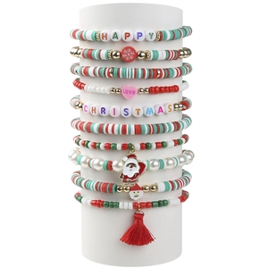 Detailed stack of Christmas clay bead bracelets with Santa and snowflake charms on white stand