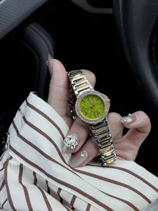Gros plan d'une montre à cadran vert avec lunette en cristal et bracelet bicolore