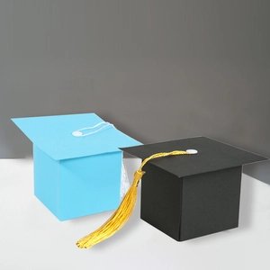 Close-up of light blue and black graduation cap gift boxes with decorative tassels
