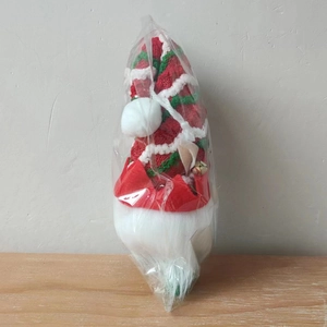 Détail d'un gnome de Noël avec bonnet à pompon et barbe en peluche dans son emballage d'origine