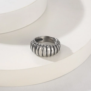 Close-up of a silver stainless steel croissant ring with a twisted spiral texture