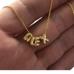 Handgehaltene Ansicht der personalisierten 18K Gold-Buchstabenkette ALEX für Damen