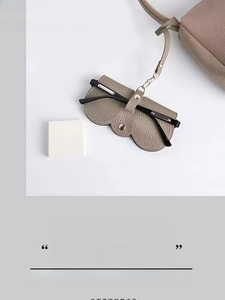 Détail de la pochette à lunettes en cuir PU taupe avec crochet en métal et lanière