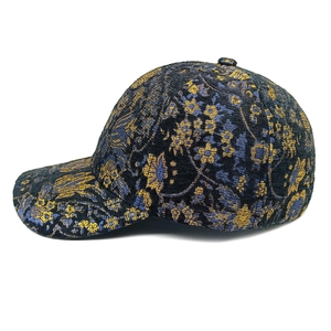 Dettaglio del cappello jacquard con motivi floreali oro e blu su tessuto blu scuro