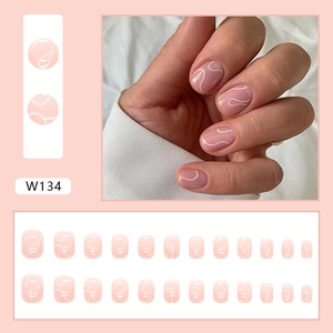 Close-up of nude pink press-on nails with white wave art and a full 24-piece set layout