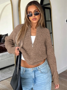 Close-up detail of the brown knit sweater featuring a stylish half-zip neckline design