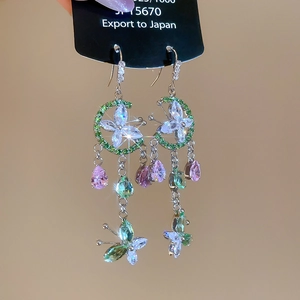 Close-up of flower glass bead tassel earrings with green zircons and silver plating