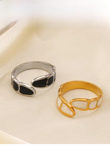 Close-up of gold and silver open rings with black and white enamel hearts on satin