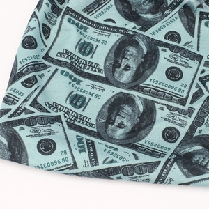 Macro view of blue knit fabric featuring detailed US dollar bill all-over print design